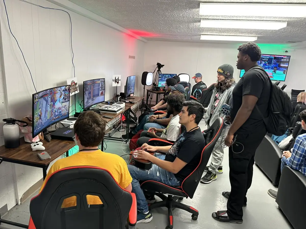 Players at fighting-game stations inside Warguts